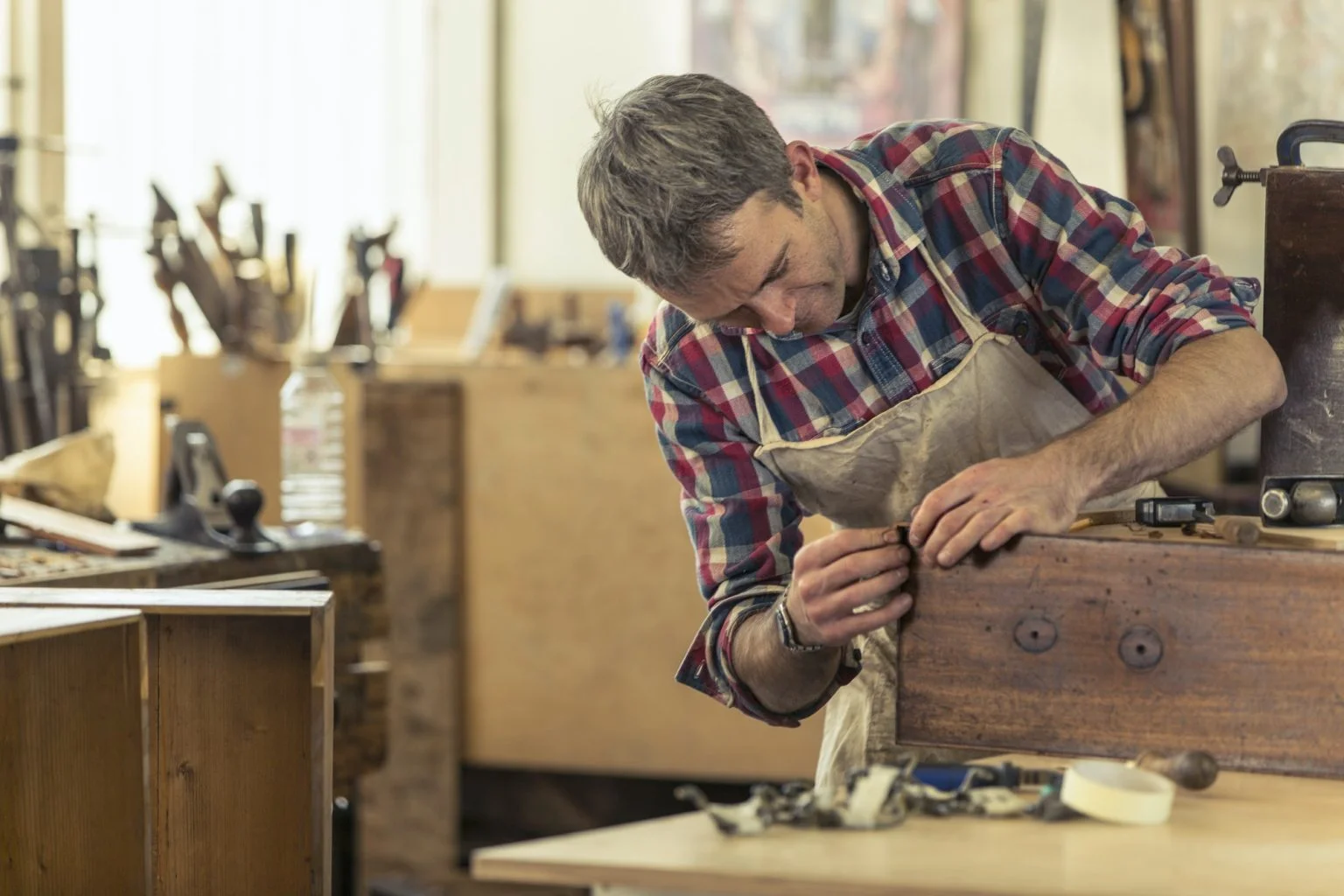 A craftsman in a workshop carving wood