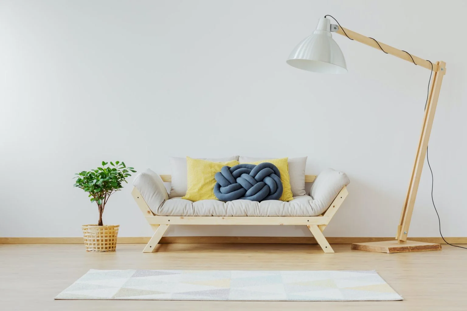 A modern living room with a comfortable sofa, decorative pillows, and a stylish lamp.